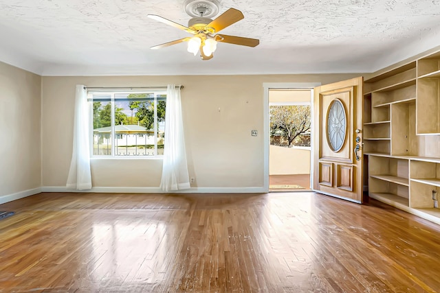 entryway with a textured ceiling, hardwood / wood-style flooring, and ceiling fan