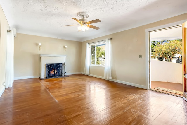 unfurnished living room with wood-type flooring, a textured ceiling, and ceiling fan