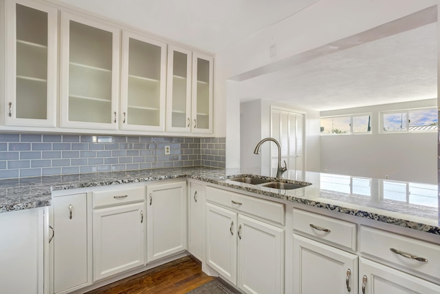 kitchen featuring decorative backsplash, sink, white cabinets, and dark wood-type flooring