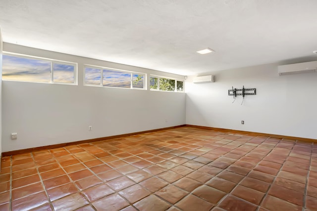 unfurnished room with a wall mounted AC and light tile patterned floors