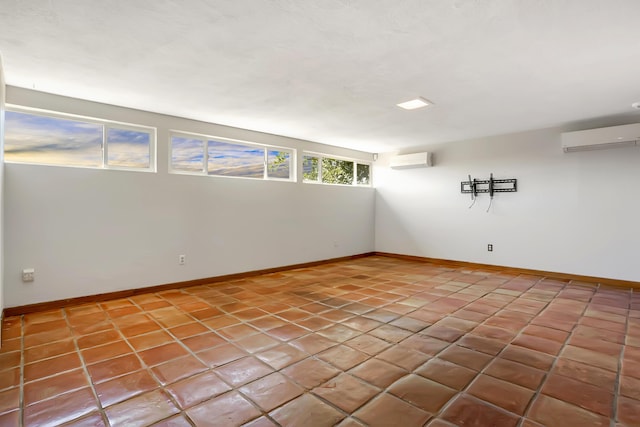 unfurnished room featuring an AC wall unit and baseboards