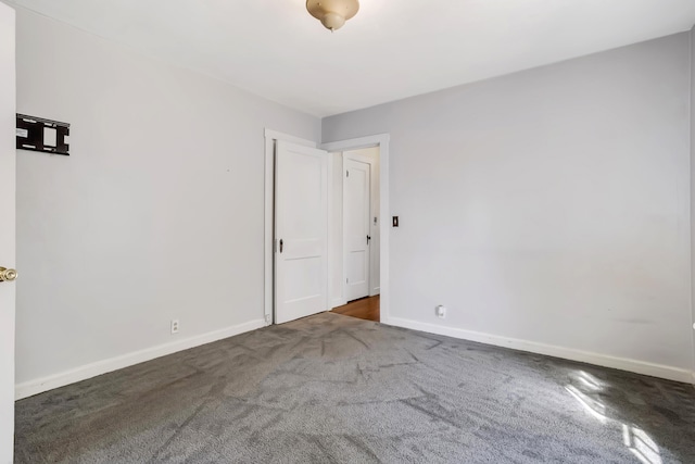 spare room with dark colored carpet