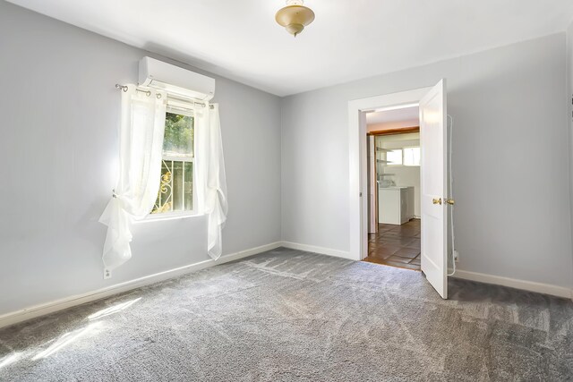 empty room featuring plenty of natural light, dark carpet, and a wall mounted AC