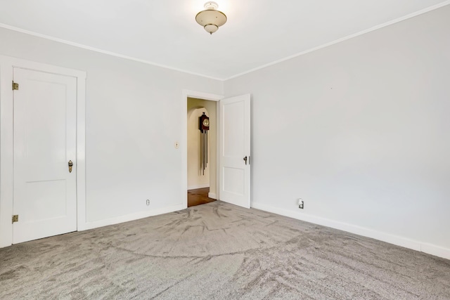 unfurnished room with baseboards, ornamental molding, and carpet flooring