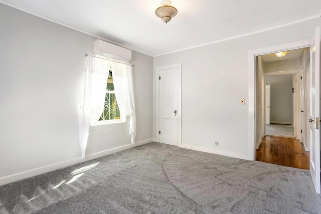 empty room featuring crown molding, carpet, baseboards, and a wall mounted air conditioner