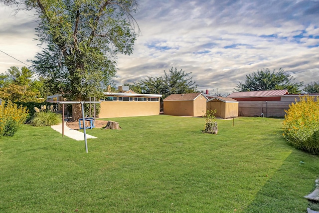 view of yard with a storage unit, an outdoor structure, and fence