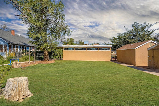 view of yard featuring a storage unit, an outdoor structure, and fence