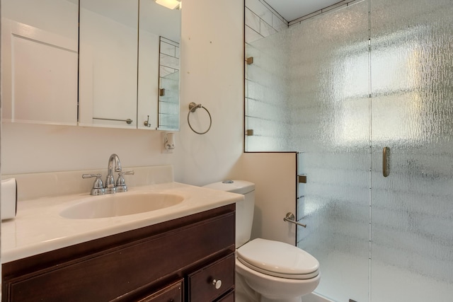 bathroom with a stall shower, toilet, and vanity