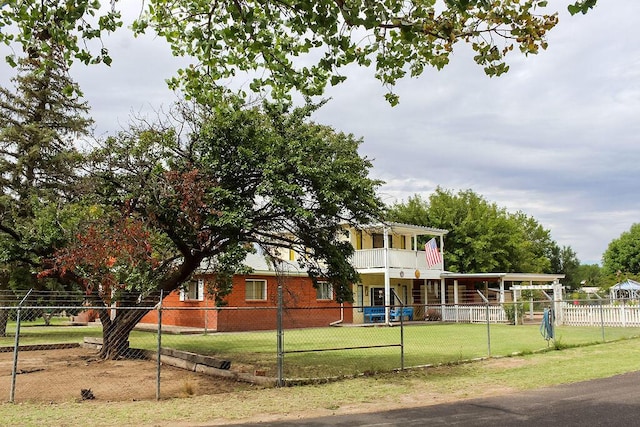 view of front of property featuring a balcony and a front lawn