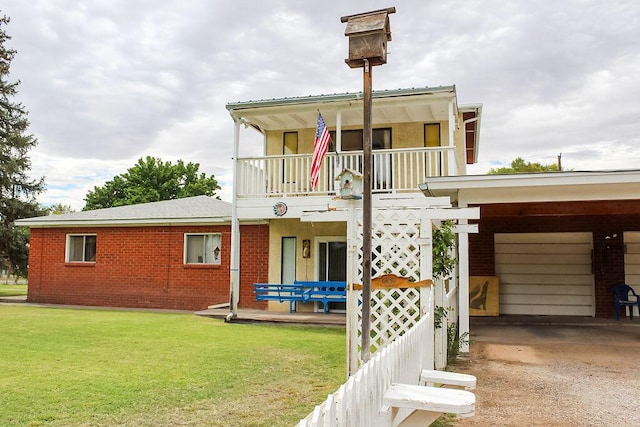 view of front of house featuring a balcony, a carport, and a front yard