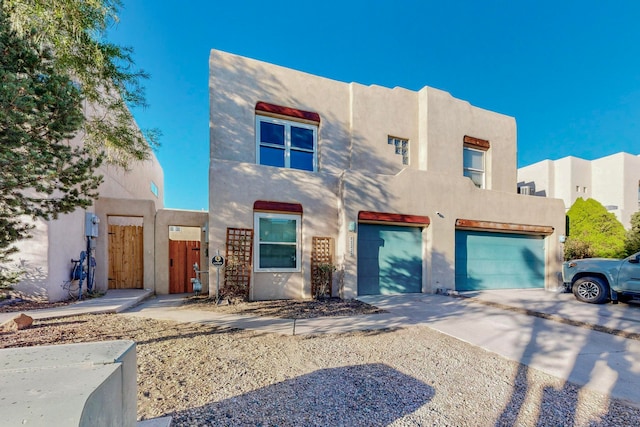 pueblo-style house featuring a garage