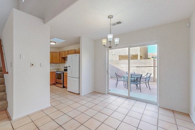 kitchen featuring stainless steel electric range, hanging light fixtures, light tile patterned floors, a chandelier, and white refrigerator