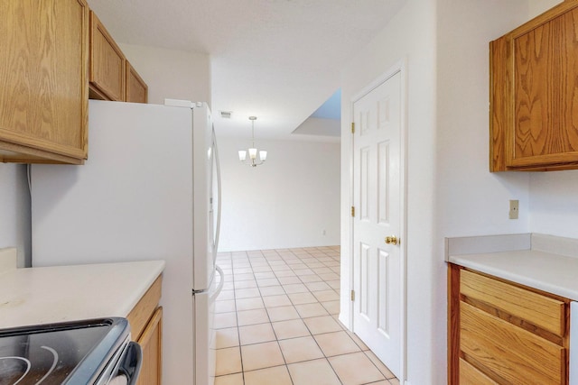 kitchen featuring light tile patterned flooring, decorative light fixtures, an inviting chandelier, white refrigerator, and stove