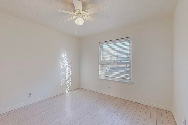 unfurnished room with a textured ceiling, light wood-type flooring, and ceiling fan