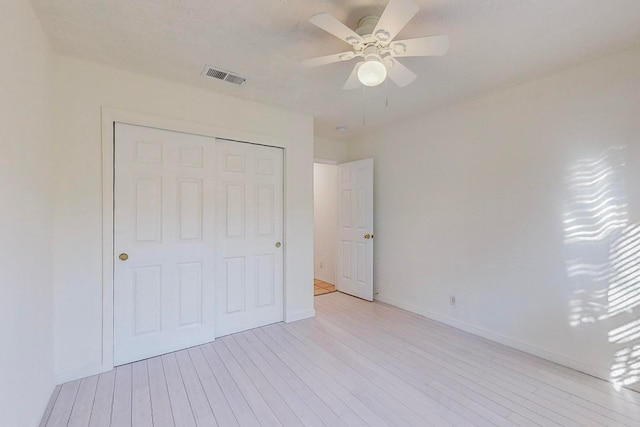 unfurnished bedroom featuring a closet, ceiling fan, and light hardwood / wood-style flooring