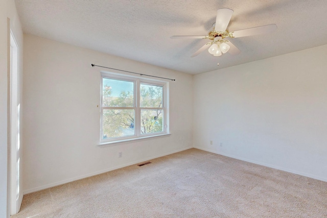 carpeted spare room featuring ceiling fan and a textured ceiling