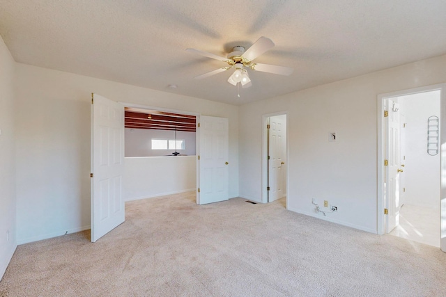 unfurnished bedroom with light carpet, a textured ceiling, and ceiling fan