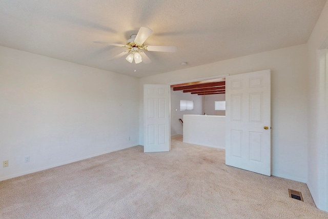 carpeted spare room featuring ceiling fan