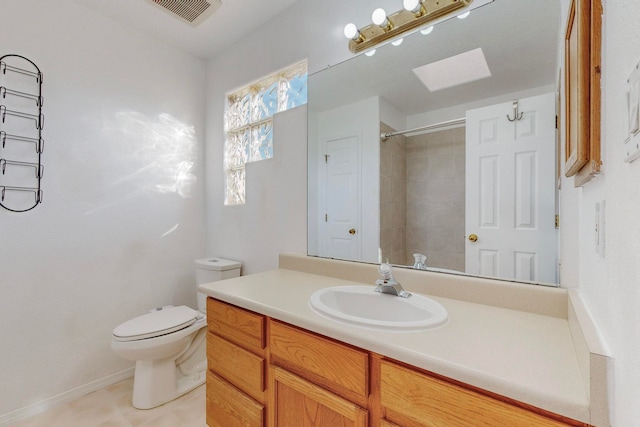 bathroom with vanity, tiled shower, and toilet