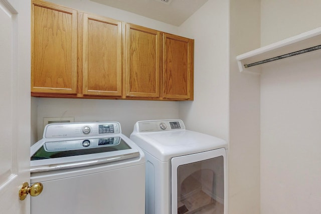 laundry area with washer and clothes dryer and cabinets