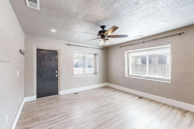 1139 Forrester Ave NW, Albuquerque, NM 87104 - spare room with a textured ceiling, visible vents, ceiling fan, light wood-style flooring, and baseboards
