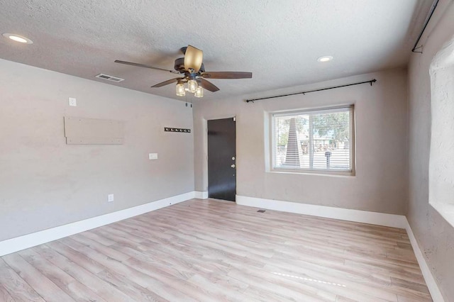 empty room featuring ceiling fan, a textured ceiling, and light wood-type flooring