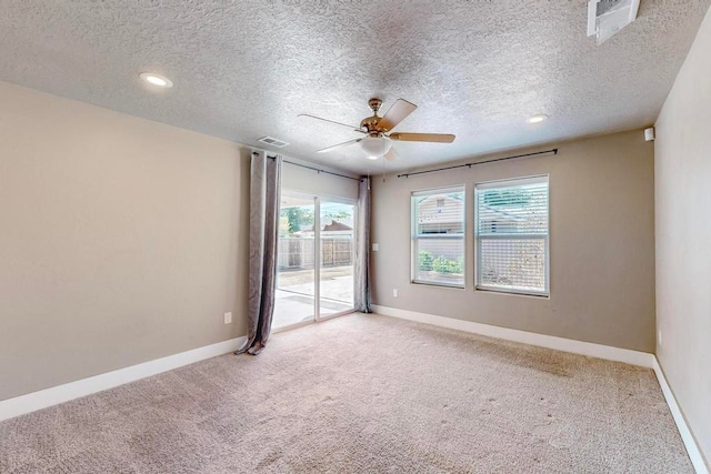 carpeted empty room featuring ceiling fan and a textured ceiling