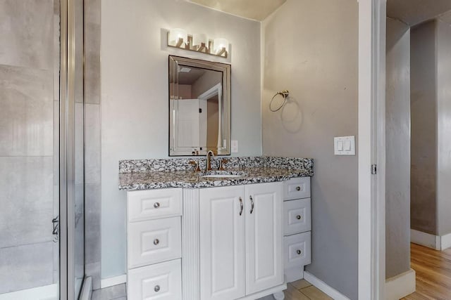 1139 Forrester Ave NW, Albuquerque, NM 87104 - bathroom featuring baseboards, a shower with shower door, and vanity