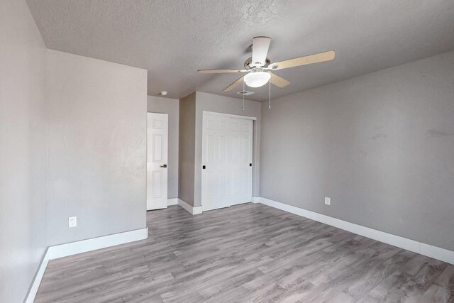 1139 Forrester Ave NW, Albuquerque, NM 87104 - unfurnished bedroom featuring a ceiling fan, a closet, a textured ceiling, baseboards, and wood finished floors