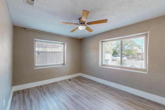 1139 Forrester Ave NW, Albuquerque, NM 87104 - unfurnished room featuring a textured ceiling, baseboards, a ceiling fan, and wood finished floors