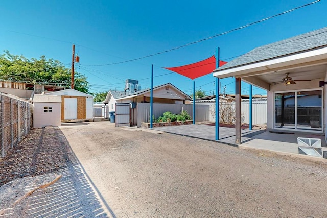 view of yard featuring a patio, a storage unit, and ceiling fan