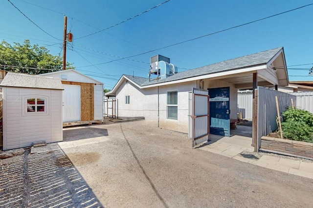 1139 Forrester Ave NW, Albuquerque, NM 87104 - rear view of house with fence, a shed, and an outbuilding