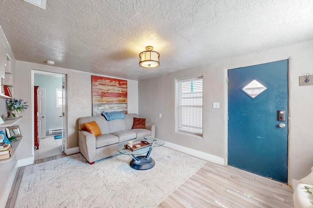 living room featuring light wood-type flooring and a textured ceiling