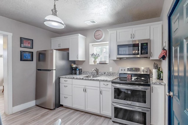 1139 Forrester Ave NW, Albuquerque, NM 87104 - kitchen featuring white cabinetry, appliances with stainless steel finishes, visible vents, and a sink