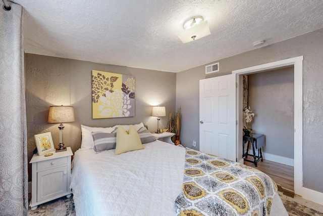 1139 Forrester Ave NW, Albuquerque, NM 87104 - bedroom featuring a textured ceiling, visible vents, wood finished floors, and a textured wall