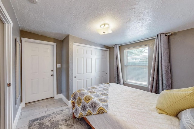 1139 Forrester Ave NW, Albuquerque, NM 87104 - bedroom with baseboards, a closet, and a textured ceiling
