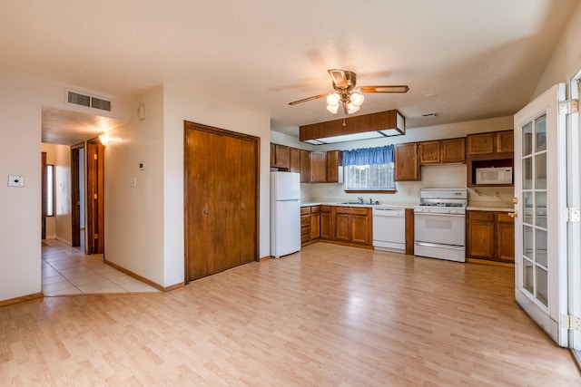 kitchen with white appliances, light hardwood / wood-style floors, sink, and ceiling fan