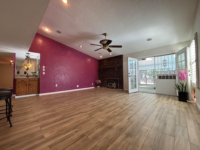 unfurnished living room featuring ceiling fan, hardwood / wood-style floors, and a textured ceiling