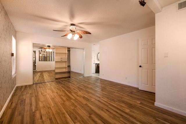 unfurnished living room with ceiling fan, hardwood / wood-style floors, and a textured ceiling