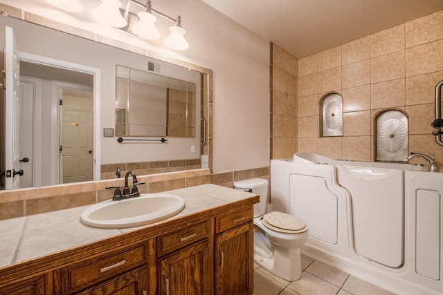 bathroom with vanity, tile walls, toilet, and tile patterned floors