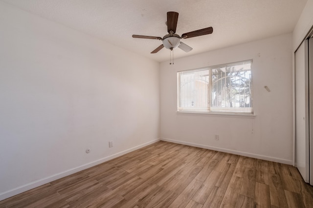 unfurnished bedroom with ceiling fan, a textured ceiling, a closet, and light hardwood / wood-style floors