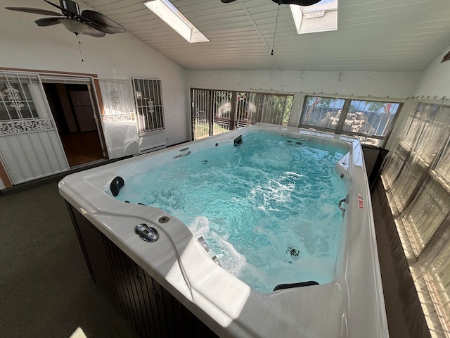 view of swimming pool with a skylight and ceiling fan