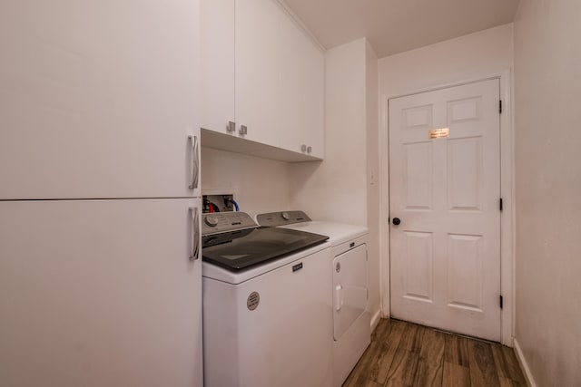 washroom with independent washer and dryer, dark hardwood / wood-style floors, and cabinets