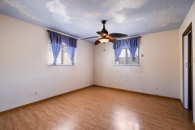 unfurnished bedroom featuring light wood-type flooring, multiple windows, and ceiling fan