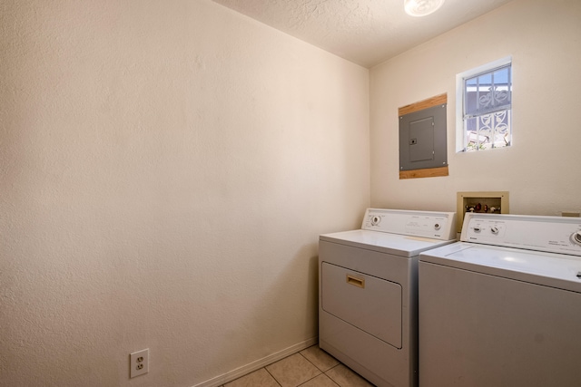 laundry room featuring electric panel, independent washer and dryer, a textured ceiling, and light tile patterned flooring