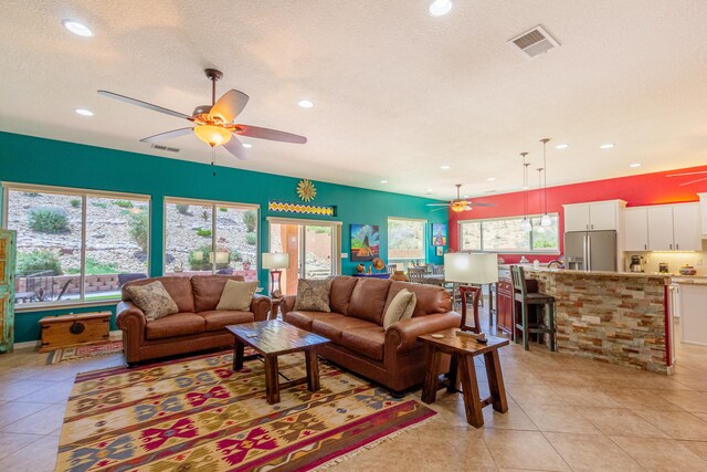 tiled living room featuring a textured ceiling and ceiling fan