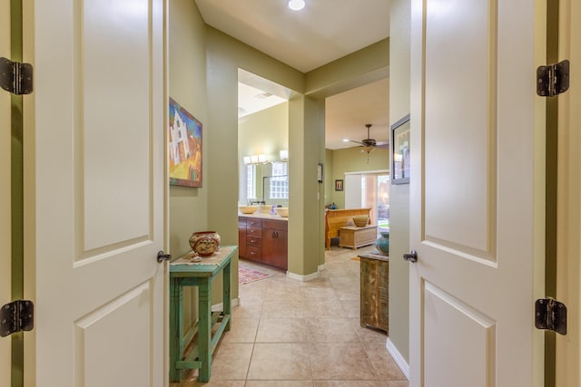 hallway with baseboards and light tile patterned floors