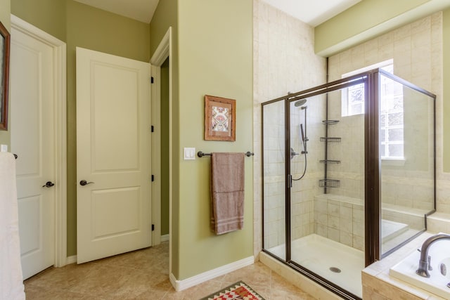 bathroom with a garden tub, a stall shower, tile patterned floors, and baseboards