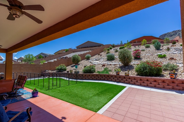 view of yard with a patio, a mountain view, ceiling fan, and a fenced backyard