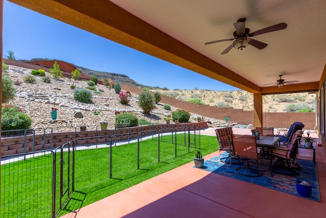 view of patio / terrace with ceiling fan and a mountain view